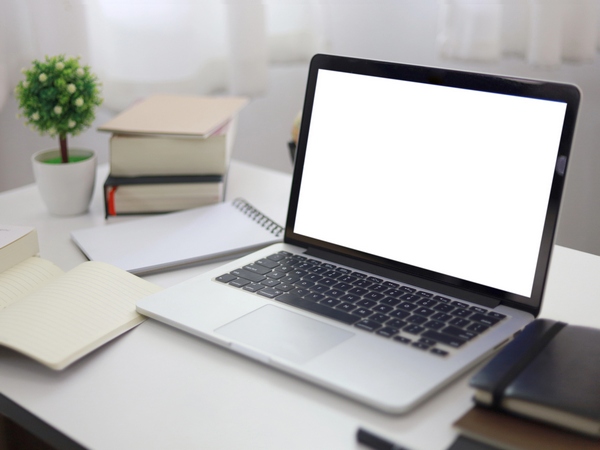 A laptop computer, notepad and reference books
